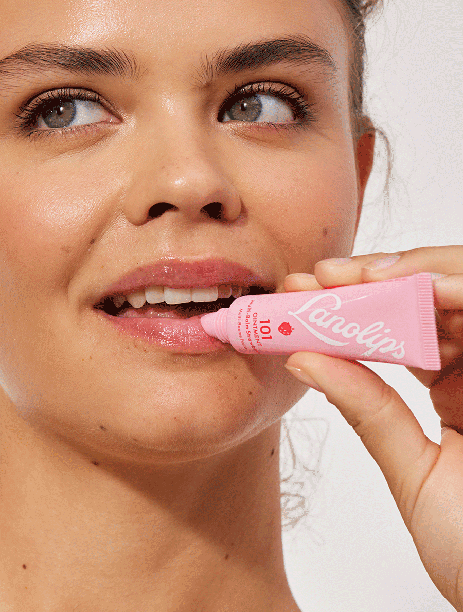 Model applying the Lanolips 101 Ointment Multi-Balm in Strawberry
