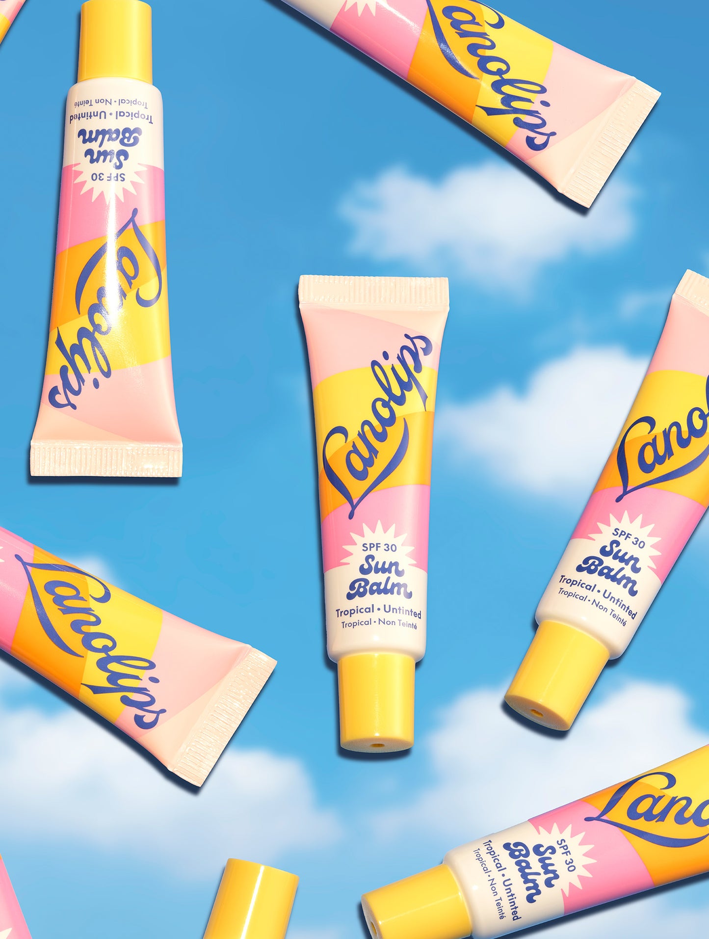 Multiple tubes of Lanolips Sun Balm SPF 30 Tropical float on a sky background - glossy, untinted, SPF-packed hydration for all-day, all-year sun protection.