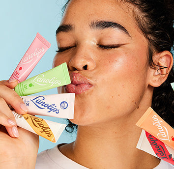 Model holding lanolips 101 ointment tubes in various flavours.