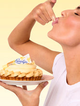 Load image into Gallery viewer, Model holding the Lanolips 101 Ointment Multi Balm Banana Cream Pie
