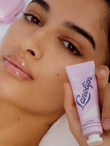 Model holding up Lanolips 12 Hour Overnight Lip Mask