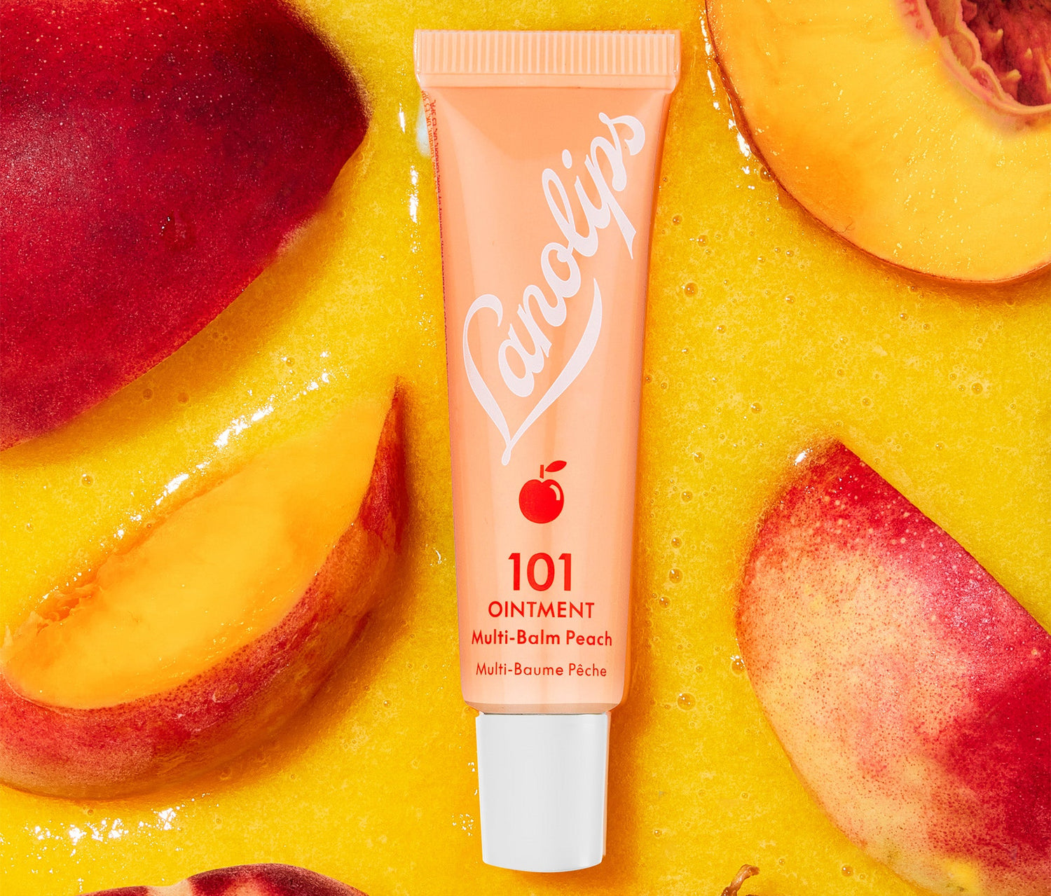 A tube of Lanolips 101 Ointment Multi Balm in Peach flavour is placed on a vibrant background of blended peach puree, surrounded by fresh peach slices. The tube features a warm peachy-orange hue and with a white Lanolilps logo and a small peach icon. The balm contains natural lanolin, vitamin e and peach kernal oil, which softens and replenishes dry lips, with a freshy fruity twist.