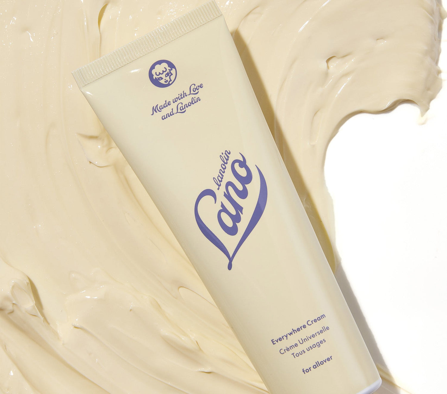 A tube of Lanolips Everywhere Cream sits on a rich, creamy texture, showcasing its ultra-hydrating formula. Infused with double lanolin, milk, and vitamin E, this all-in-one moisturiser deeply nourishes dry, thirsty skin. It transforms ashy, dehydrated skin into a soft, glowing complexion. A true multitasker, it replaces face cream, hand cream, body lotion, and even baby cream—perfect for all-over hydration, day or night.
