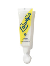 Load image into Gallery viewer, Lanolips Lemonaid Lanolin Lip Treatment in a sleek, squeezable tube with a white cap and a bright yellow diagonal design. The packaging features the Lanolips logo in bold blue lettering and an illustration of a lemon slice, highlighting its citrus-infused, ultra-hydrating formula. The lip treatment has a glossy, rich texture designed to nourish, exfoliate, and soften dry lips with a refreshing lemon scent.
