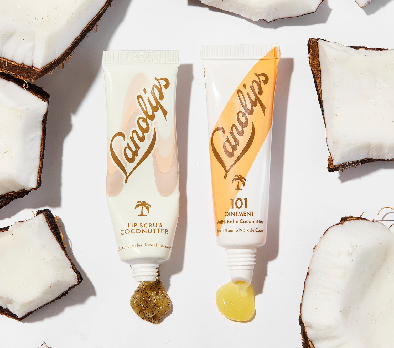 Lanolips Lip Rituals Scrub & Balm Coconutter Duo shown with product textures and coconut pieces. Includes Lip Scrub Coconutter with real fruit pieces for gentle exfoliation, and 101 Ointment Multi Balm Coconutter for intense hydration. Made with 100% natural ingredients and lanolin for smooth, nourished lips.
