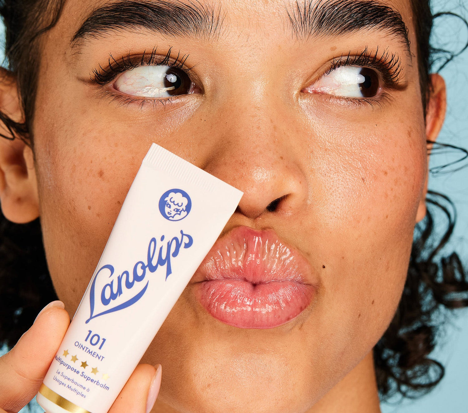 A model puckers her lips while holding a tube of Lanolips The Original 101 Ointment Multipurpose Superbalm close to her face. This 100% natural, multi-award-winning balm is a powerful multi-tasker with 101 uses—from ultra-hydrating lips to soothing dry skin. Voted ‘The World’s Best Lip Balm,’ it’s a hard-working formula designed to deeply nourish and lock in moisture. Made with 100% ultra-pure grade lanolin, it mimics the skin’s natural oils, leaving lips soft, smooth and glossy.