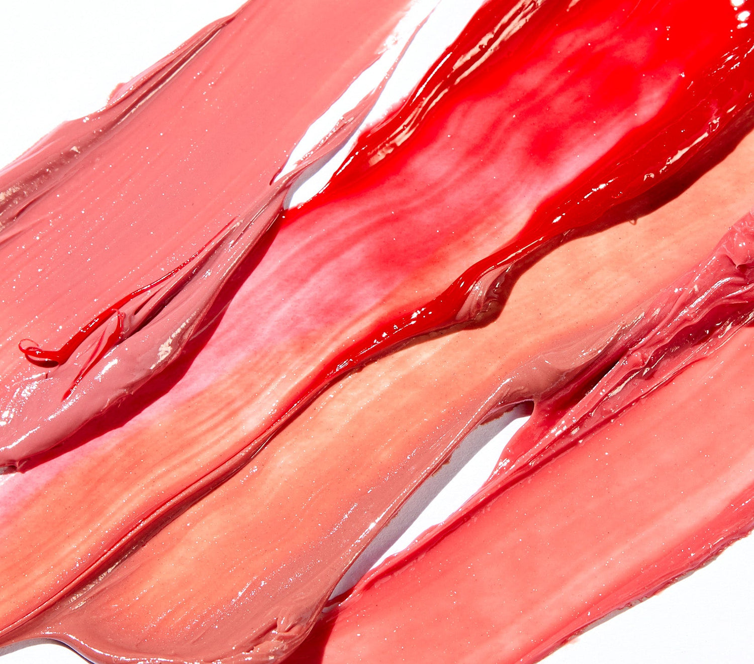 Swatches of Lanolips Tinted Lip Balm SPF 30 in shades Perfect Nude, Red Apple, Rhubarb, and Rose are spread across a white background, showcasing their sheer, glossy finish. This lanolin-rich lip moisturiser provides deep hydration while delivering a sheer colour tint for a natural, healthy glow. Infused with SPF 30, it protects lips from sun damage while keeping them soft and supple. The lightweight, non-sticky formula enhances lips with a dewy, tinted shine, making it the perfect everyday essential.