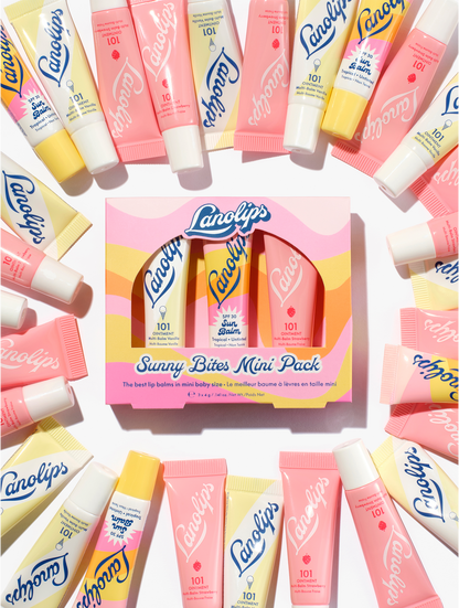 Lanolips sunny bites mini pack containing three mini lip balms, 101 ointment vanilla, strawberry and sun balm spf 30 tropical in a pink and yellow wavy box.