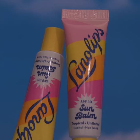 Video of the Lanolips Sun Balm SPF 30 Tropical lip balm - showing montage shots of the product, as well as the model applying the lip balm on their lips. An SPF lip balm you’ll reach for daily, tested to meet global UVA/UVB 
