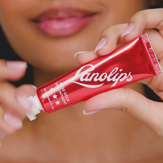 A video of a model applying and wearing Lanolips Rose Gold 101 Ointment, unveiling a dense, rich rose gold tint that enhances lips and cheeks with a natural, flushed glow. The ultra-hydrating formula delivers a dewy, non-sticky finish, mimicking the effect of blood rushing to the skin for a healthy, radiant look.